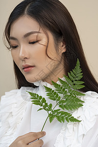 拿着叶子的美妆女性图片