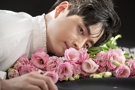 躺在花朵上的男青年图片