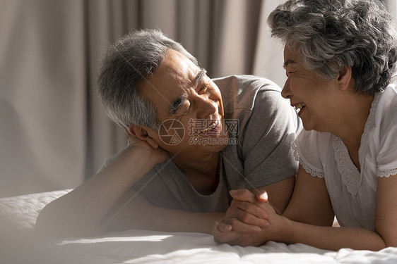床上聊天开心的老年夫妇图片