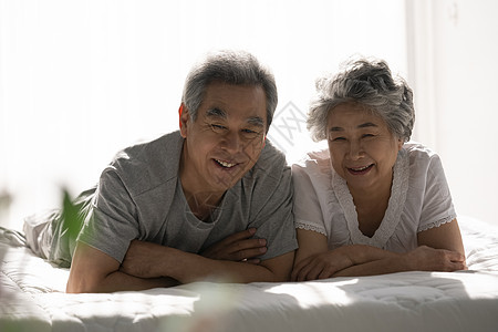 趴在卧室床上开心的老年夫妇图片