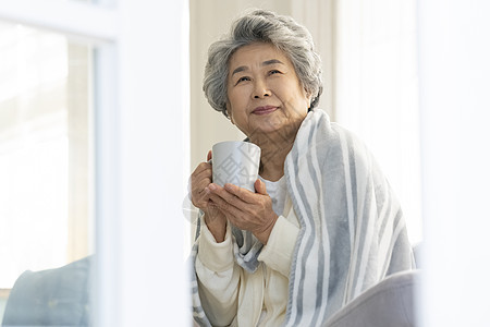 感冒拿着水杯的老年人奶奶图片