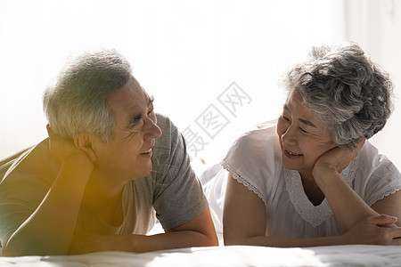 趴在床上开心的老年夫妇图片