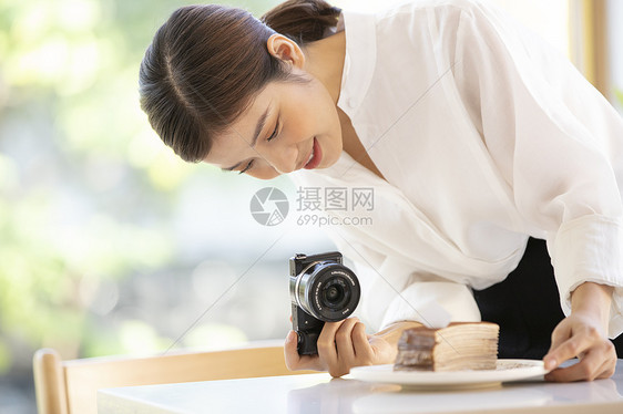 拍摄食物照片的年轻女子图片