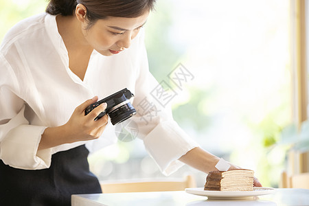 拍摄食物照片的年轻女子图片