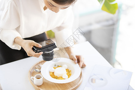 拍摄食物照片的年轻女子图片