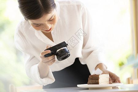 拍摄食物照片的年轻女子图片