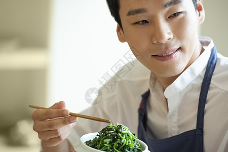 手拿筷子品尝餐点的厨师图片