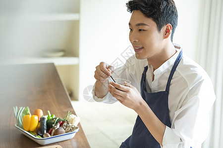 青年厨师调制酱料图片