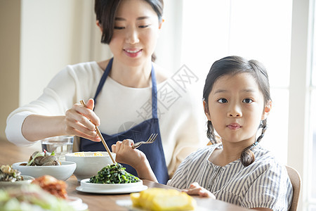 母亲照顾女儿吃饭图片