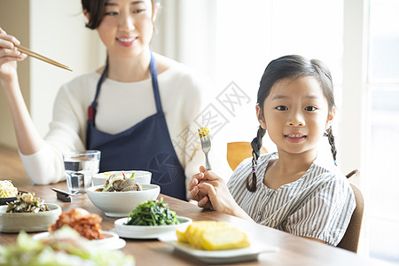 餐桌上用餐的母女高清图片