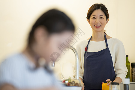 厨房戴着围裙微笑的青年女子图片