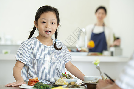 餐桌上吃饭的小女孩图片