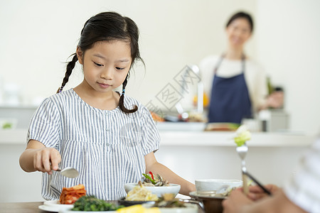 餐桌上用餐的小女孩图片