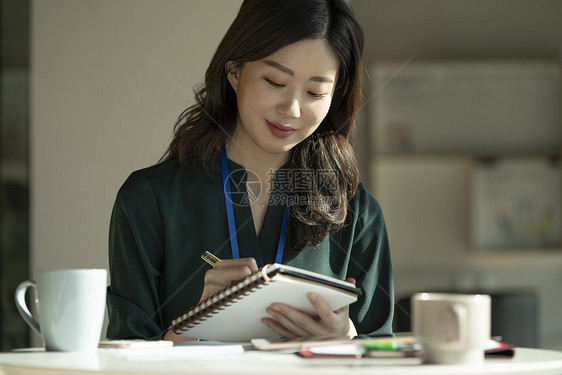 拿着本子记录的商务女性图片