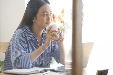 便携电脑女士美丽一个女人在家里工作图片