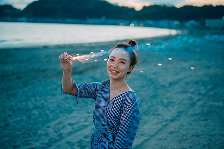 年轻美女海边玩烟花图片