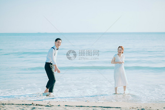 海边玩耍的新婚夫妻图片