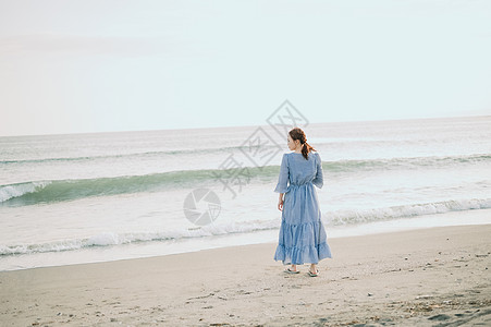 海滩上漫步的年轻女子图片