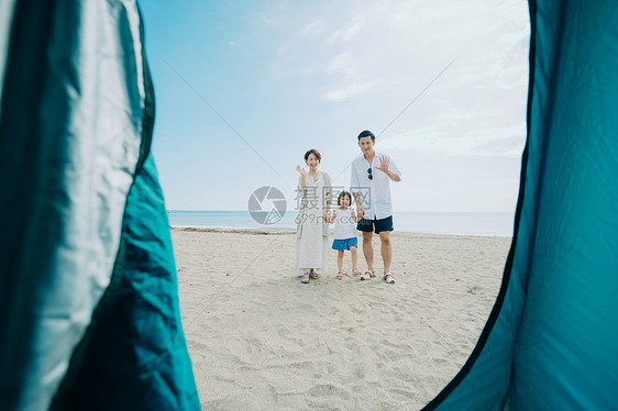 海滩上旅游露营的一家三口背影图片