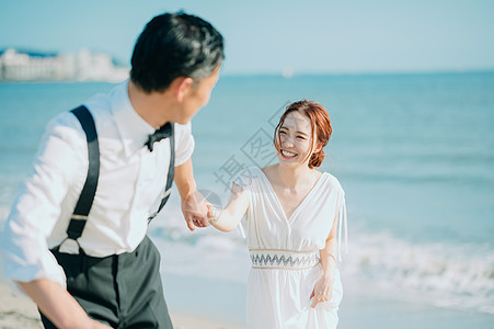 海边漫步浪漫的新婚夫妇图片