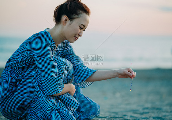 海滩上放烟花的年轻女子图片