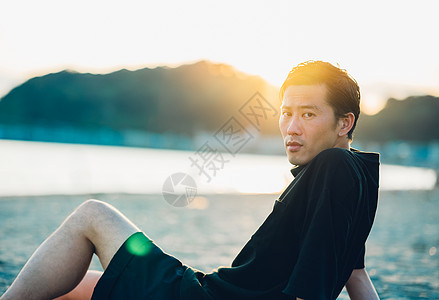 坐在海滩上的成年男子图片