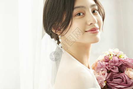婚礼花束穿着婚纱的美丽新娘抱着手捧花背景