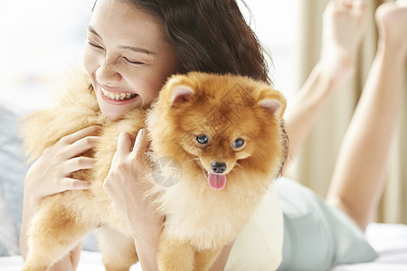 年轻女性开心的抱着狗狗图片