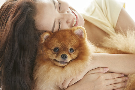年轻女性开心的抱着狗狗图片