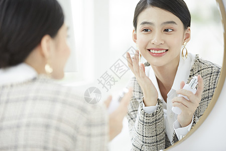 漂亮女人照着镜子梳妆打扮图片素材