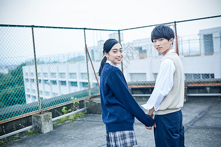 下雨天背影天台上的高中男生女生牵手背景