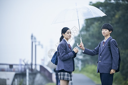 上下学路上的高中男生女生一起撑伞图片素材