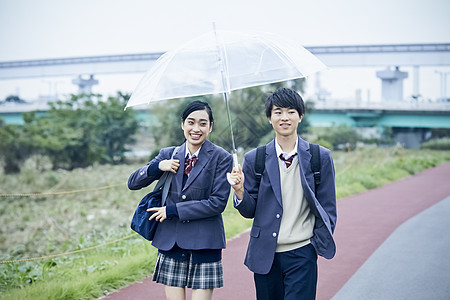 上下学路上的高中男生女生一起撑伞走路聊天图片
