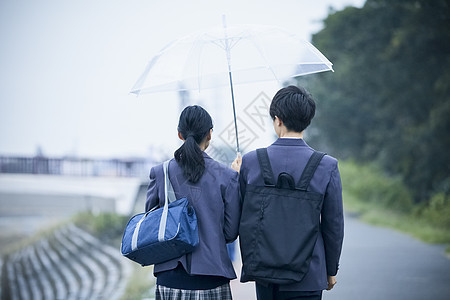 上下学路上的高中男生女生一起撑伞走路聊天图片