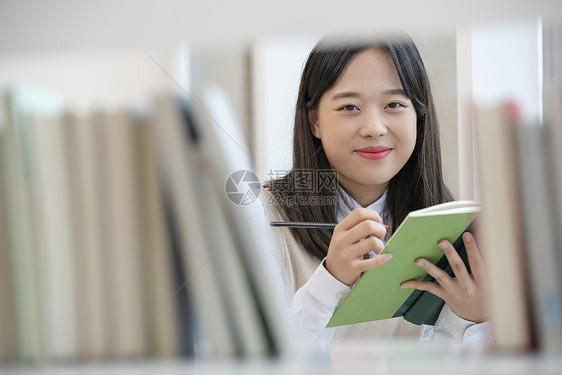 高中女学生在书架上查找书本图片