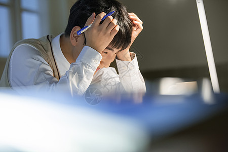 高中男学生夜晚学习苦恼图片