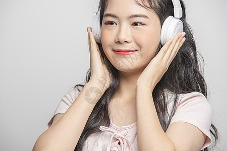 年轻女生戴着耳机听音乐图片