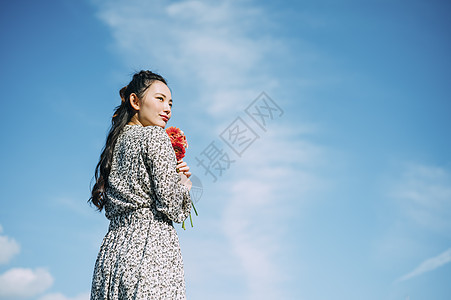 假日流行花卉拿着花的妇女的画象图片