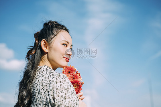 女士们微笑室外拿着花的妇女的画象图片