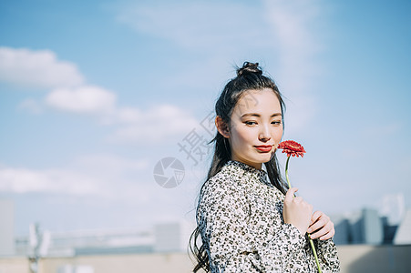 1人外出笑脸拿着花的妇女的画象图片