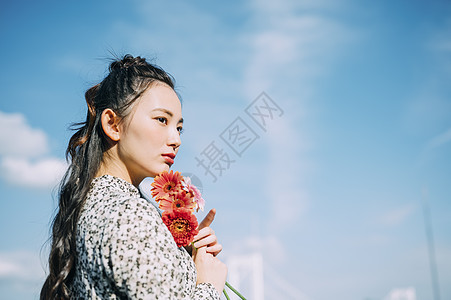 新鲜模型掌握拿着花的妇女的画象图片