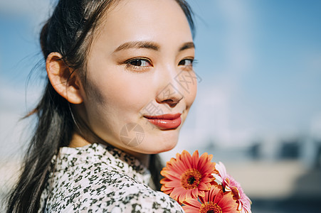 模特儿站立美女拿着花的妇女的画象图片