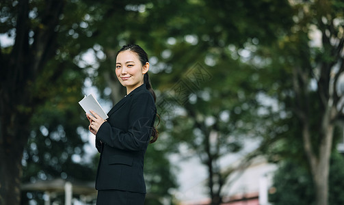 拿着书微笑的职业女性图片