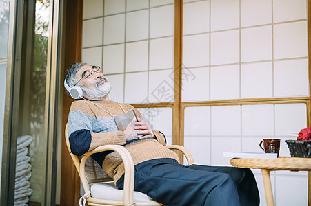 躺在椅子上看书的老人图片