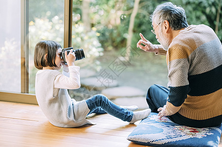 孙女用相机给爷爷拍照图片