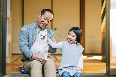 坐在庭院里的祖孙和博美图片