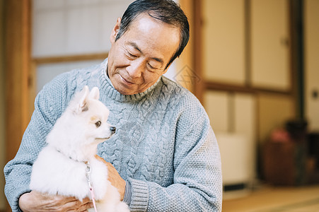 抱着博美犬的老人图片