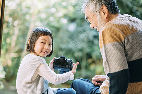 孙女用相机给爷爷拍照图片