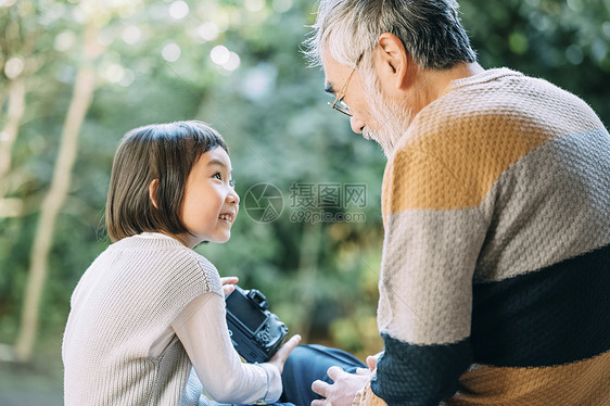 孙女用相机给爷爷拍照图片