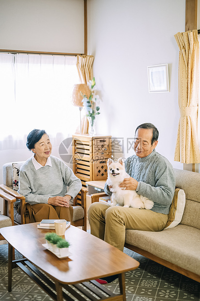 沙发上抱着博美犬的祖孙图片